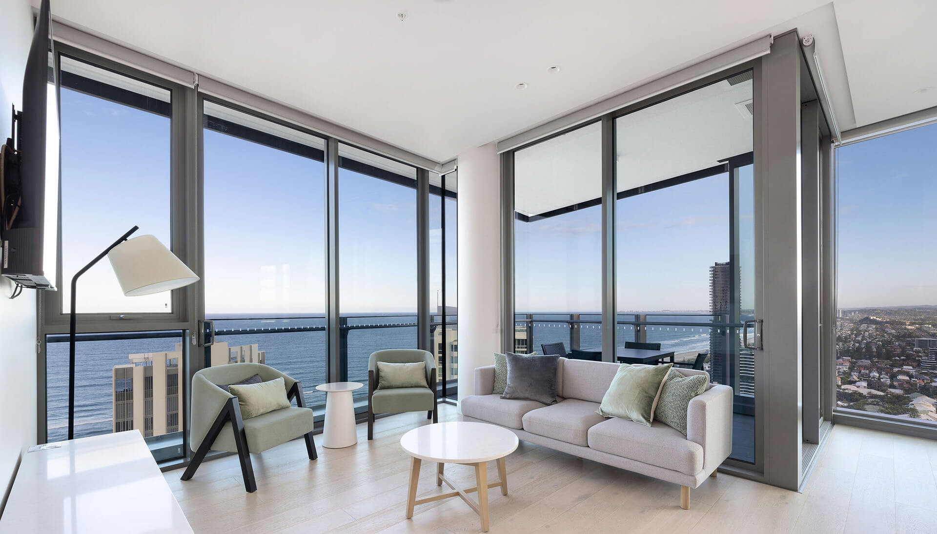 Modern living room at ULTIQA Signature at Broadbeach with floor-to-ceiling windows, ocean views, and contemporary furnishings.