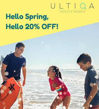 Family enjoying the beach with boogie board, promoting ULTIQA Hotels & Resorts spring offer of 20% off.